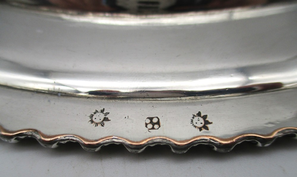 A circular Georgian Old Sheffield silver-plated dinner plate featuring a gadrooned rope-twist rim and an engraved armorial crest on the edge. View VIII