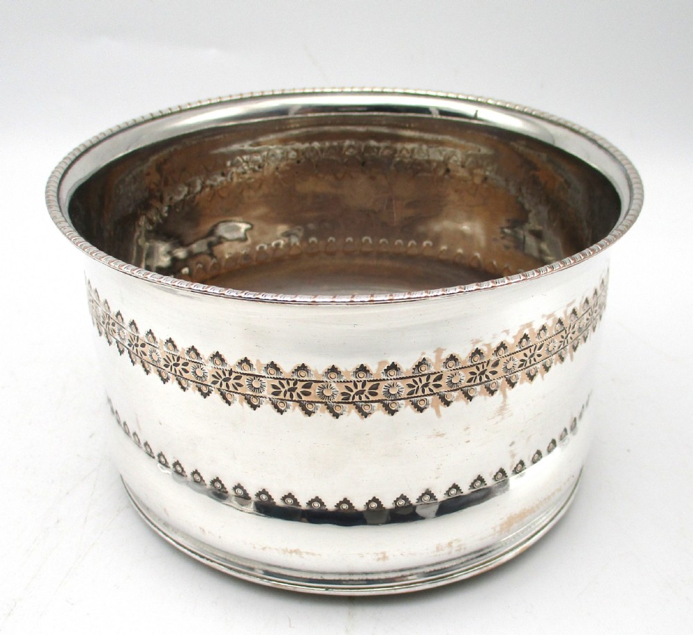 A pair of deep, circular silver-plated wine coasters featuring pierced floral decorative bands, beaded rims, and inset wooden bases. View II