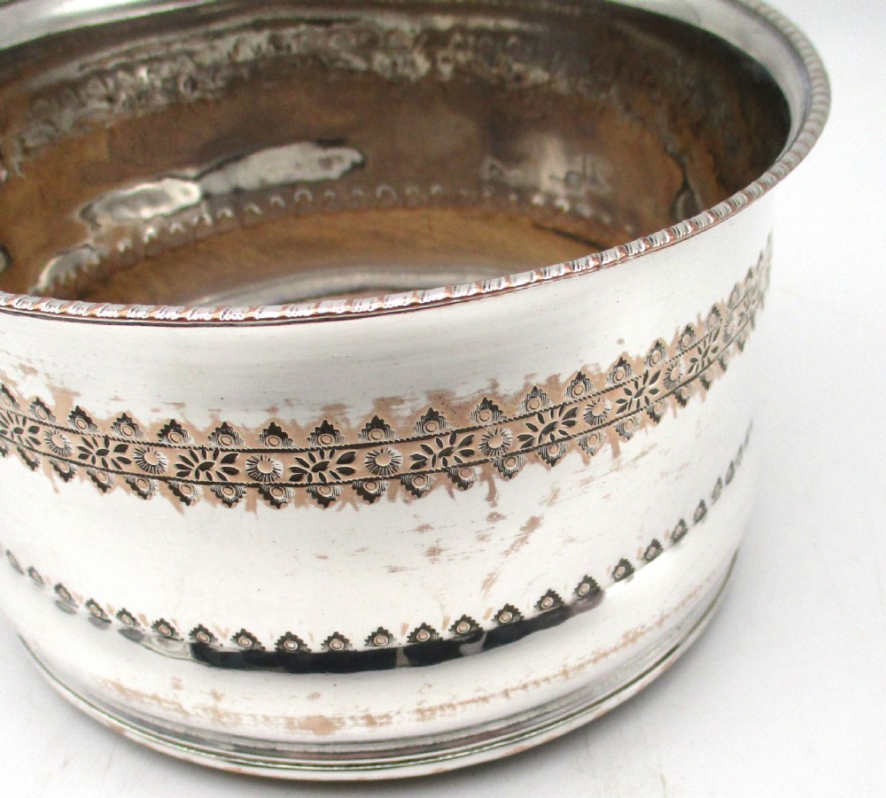 A pair of deep, circular silver-plated wine coasters featuring pierced floral decorative bands, beaded rims, and inset wooden bases. View IV