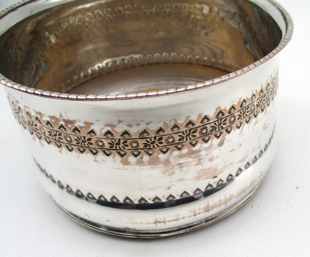 A pair of deep, circular silver-plated wine coasters featuring pierced floral decorative bands, beaded rims, and inset wooden bases. View VIII