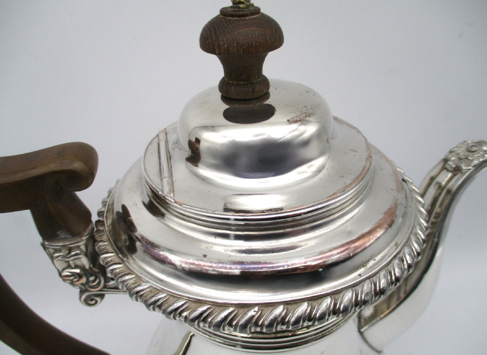 An antique Regency silver-plated coffee pot featuring a carved wooden handle, a gadrooned rim, and a stepped circular base. View III