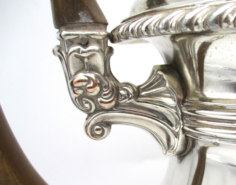 An antique Regency silver-plated coffee pot featuring a carved wooden handle, a gadrooned rim, and a stepped circular base. View IV