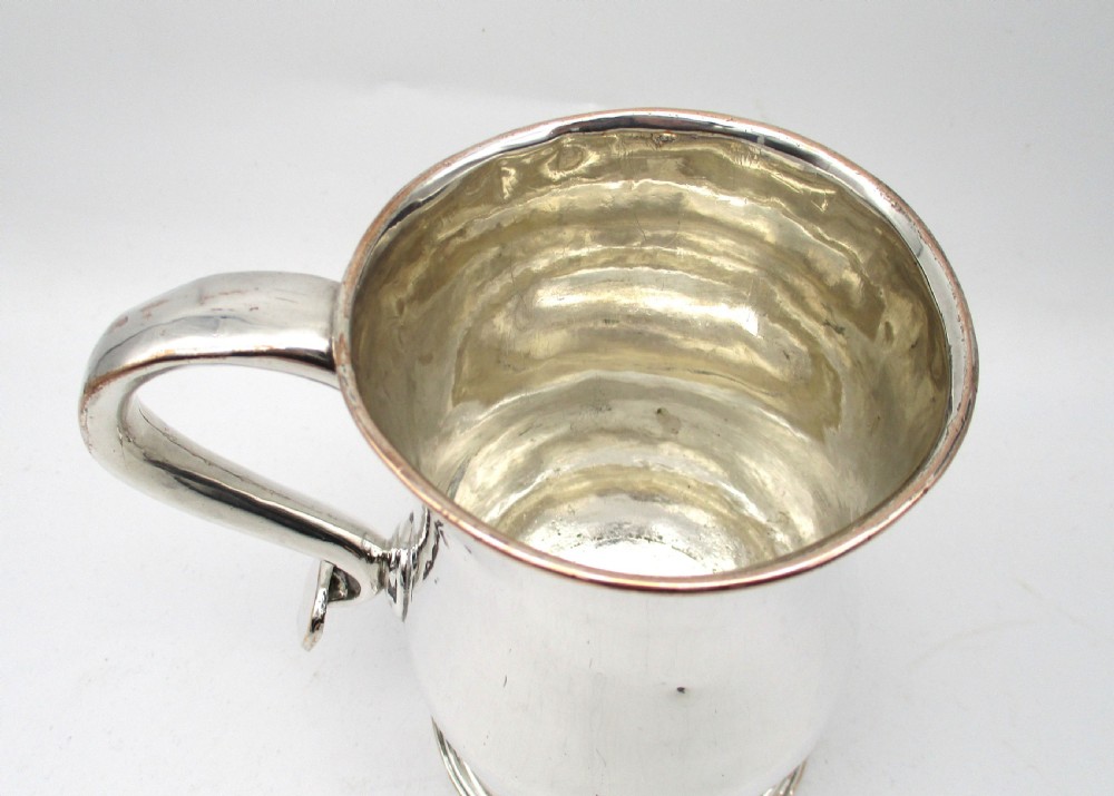An 18th-century Old Sheffield Plate silver tankard featuring a baluster body, scroll handle, and stepped circular base. View IV