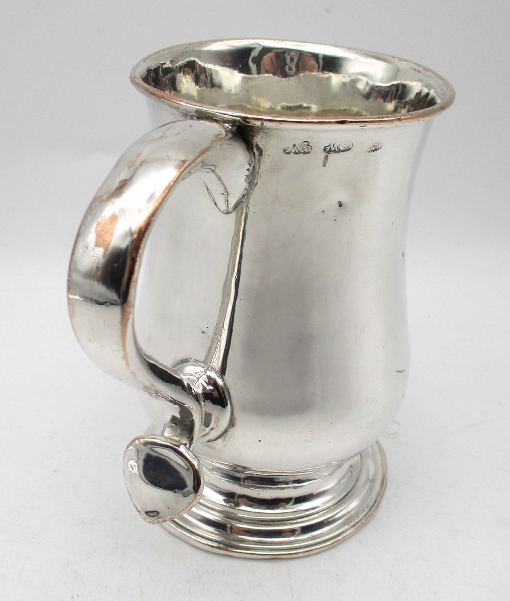 An 18th-century Old Sheffield Plate silver tankard featuring a baluster body, scroll handle, and stepped circular base. View V