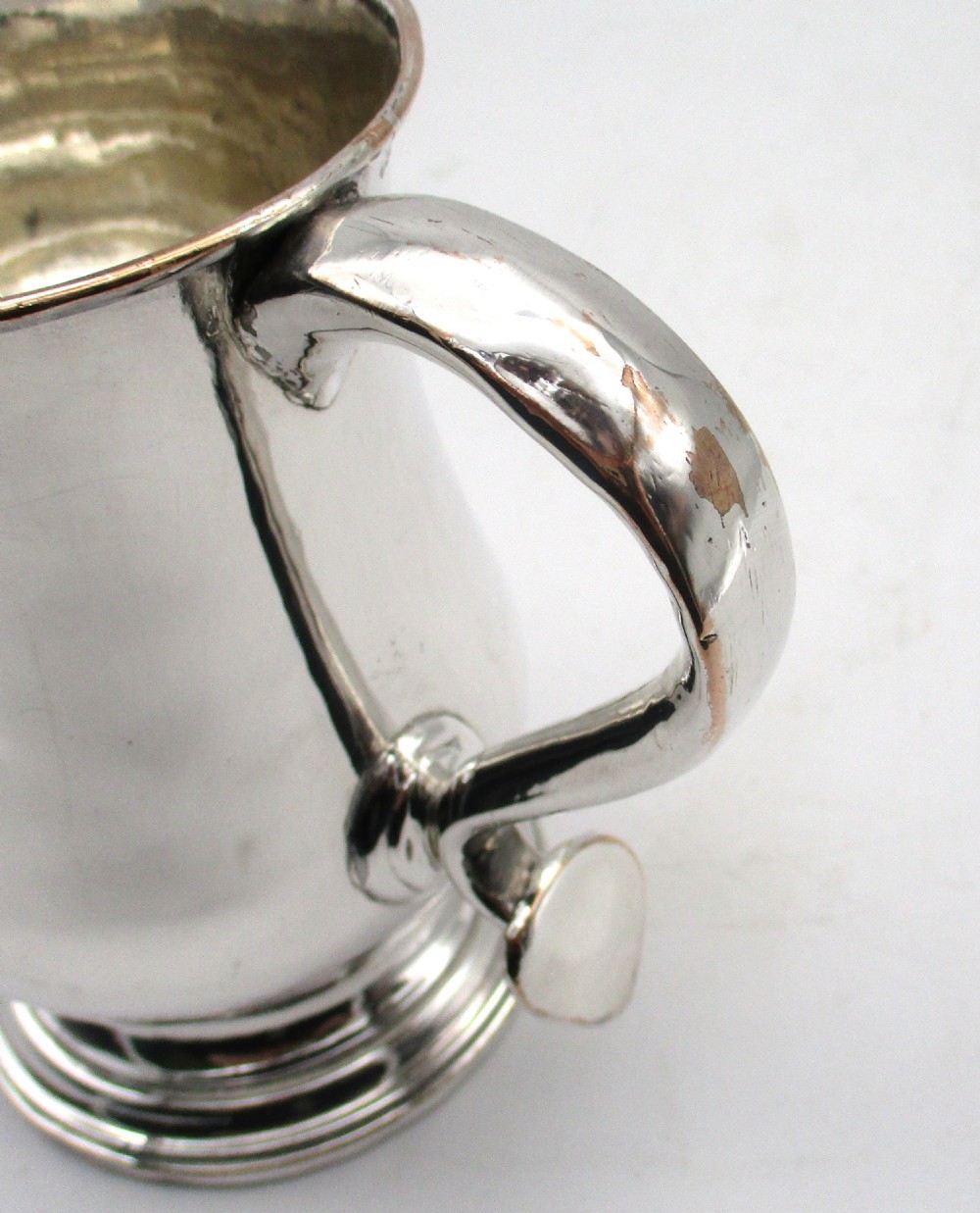 An 18th-century Old Sheffield Plate silver tankard featuring a baluster body, scroll handle, and stepped circular base. View IX