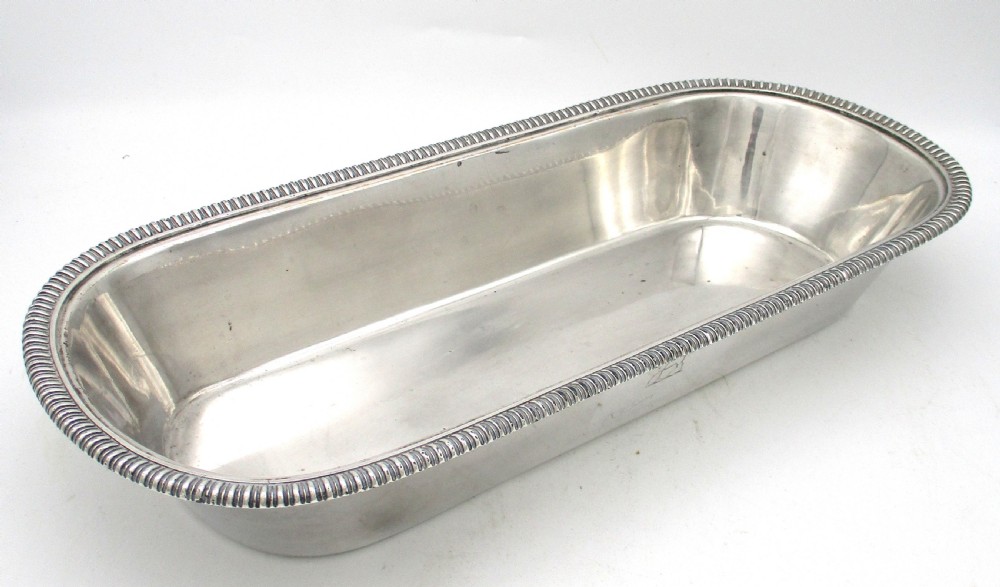 An oblong silver-plated knife tray featuring a gadrooned rim and a smooth polished interior well.