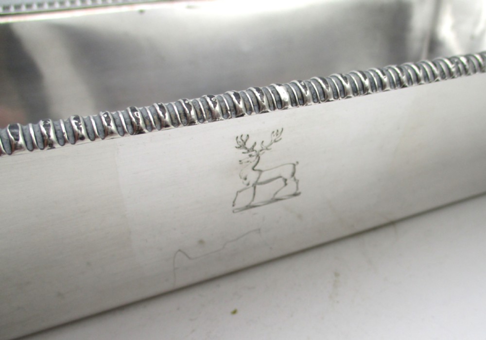 An oblong silver-plated knife tray featuring a gadrooned rim and a smooth polished interior well. View II