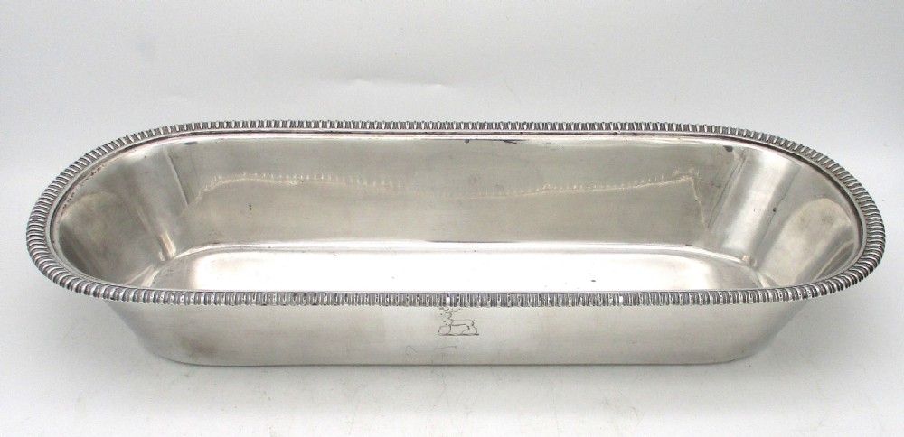 An oblong silver-plated knife tray featuring a gadrooned rim and a smooth polished interior well. View V