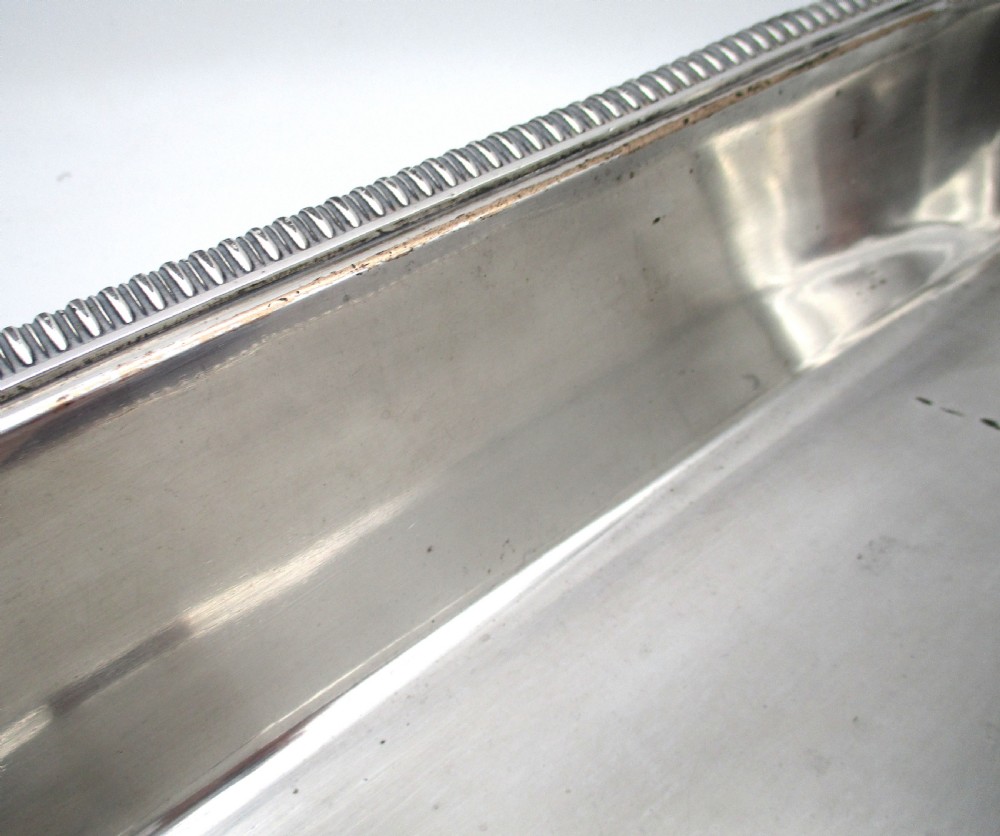 An oblong silver-plated knife tray featuring a gadrooned rim and a smooth polished interior well. View VII