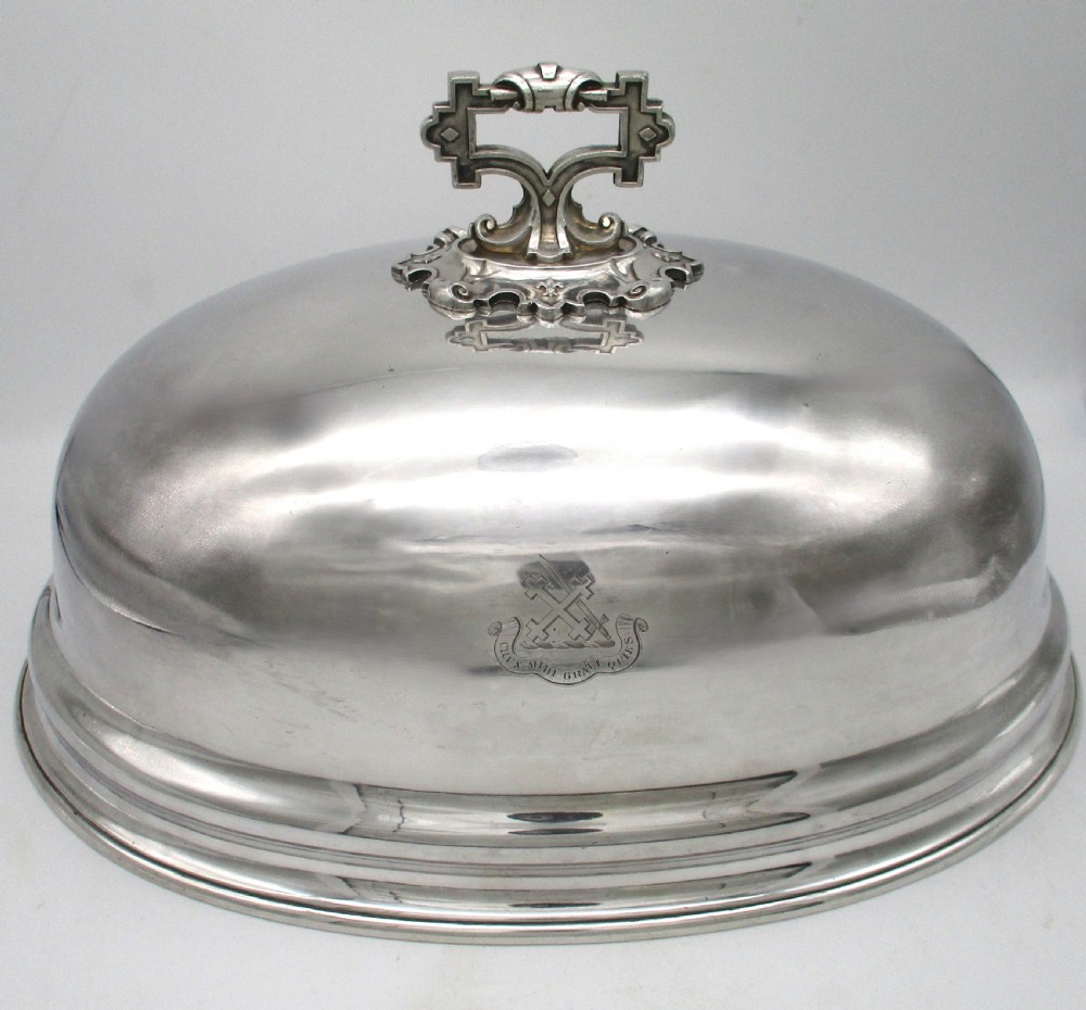 An oval Old Sheffield Plated meat dome featuring a moulded rim, an engraved crest, and a cast scrolling handle. View II