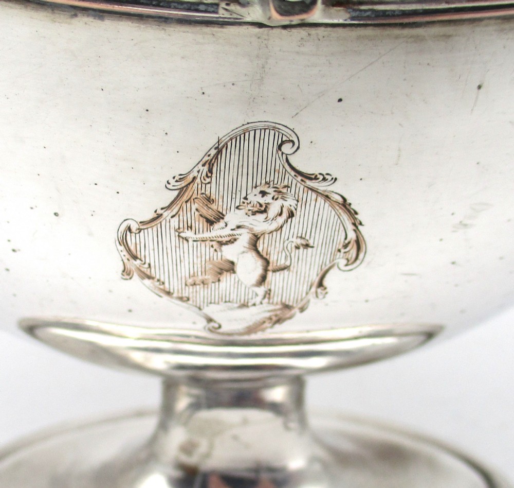 An eighteenth-century boat-shaped silver plated sweetmeat basket featuring a pedestal base, swing handle, heraldic crest engraving, and a gilded interior. View III
