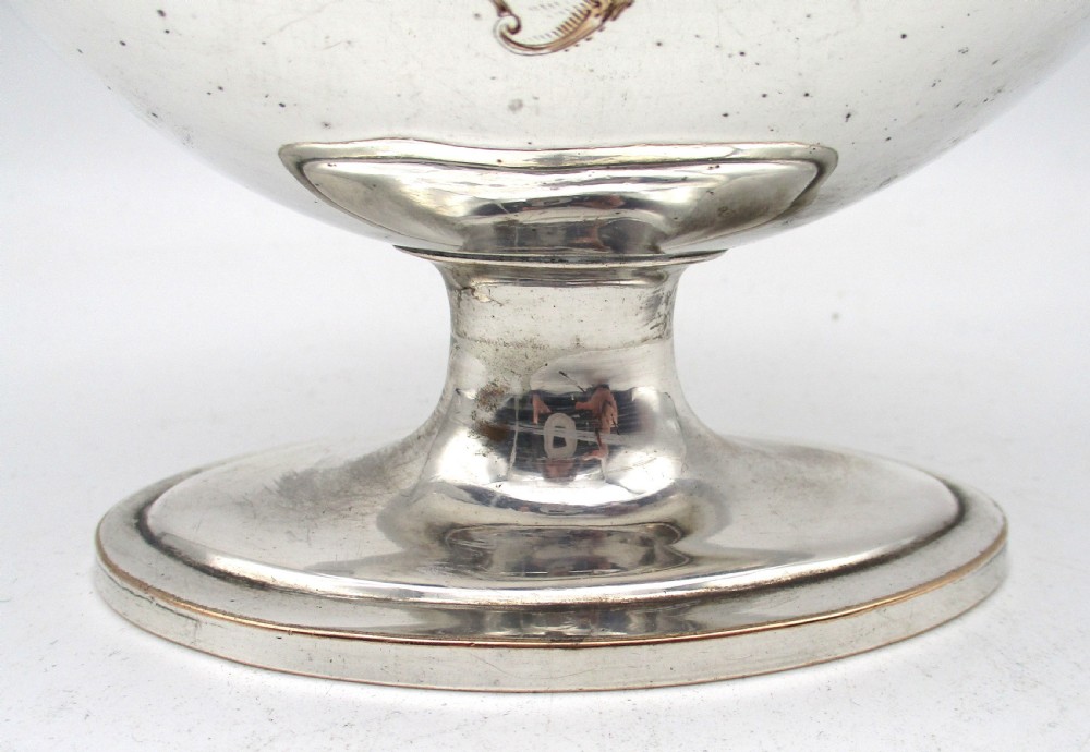 An eighteenth-century boat-shaped silver plated sweetmeat basket featuring a pedestal base, swing handle, heraldic crest engraving, and a gilded interior. View IV