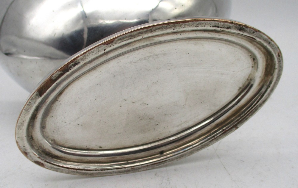 An eighteenth-century boat-shaped silver plated sweetmeat basket featuring a pedestal base, swing handle, heraldic crest engraving, and a gilded interior. View X