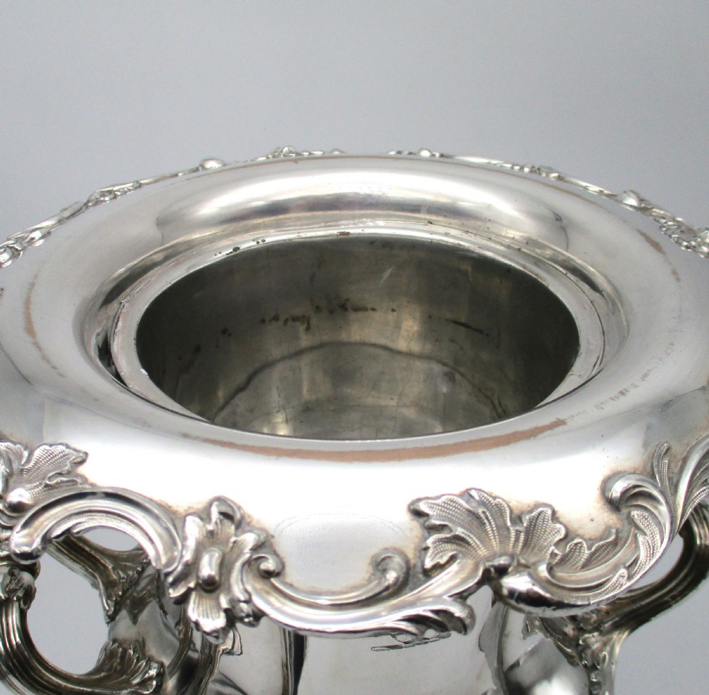 A pair of silver-plated urn-shaped wine coolers featuring scalloped foliate rims, acanthus leaf handles, and flared pedestal bases. View VI