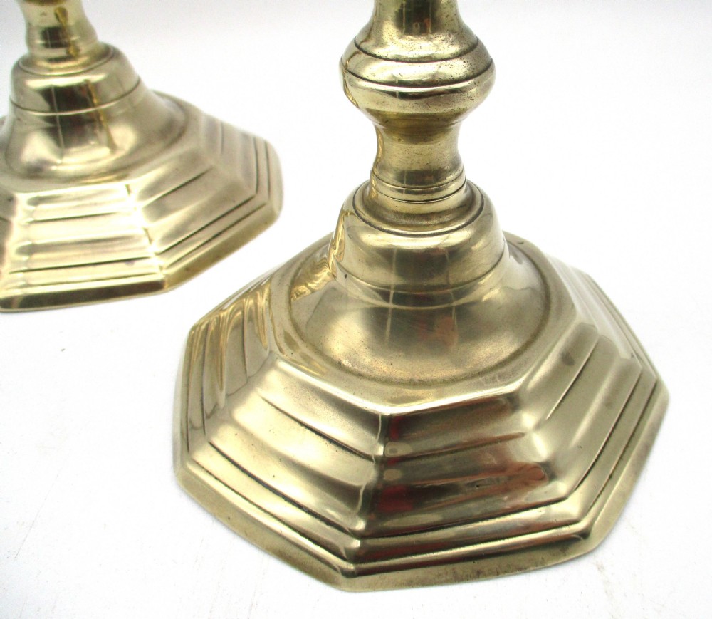 A matching pair of yellow-gold brass candlesticks featuring octagonal stepped bases and knopped stems. View IV