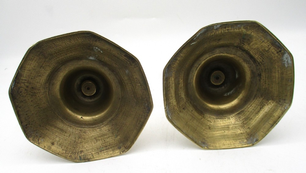 A matching pair of yellow-gold brass candlesticks featuring octagonal stepped bases and knopped stems. View VI