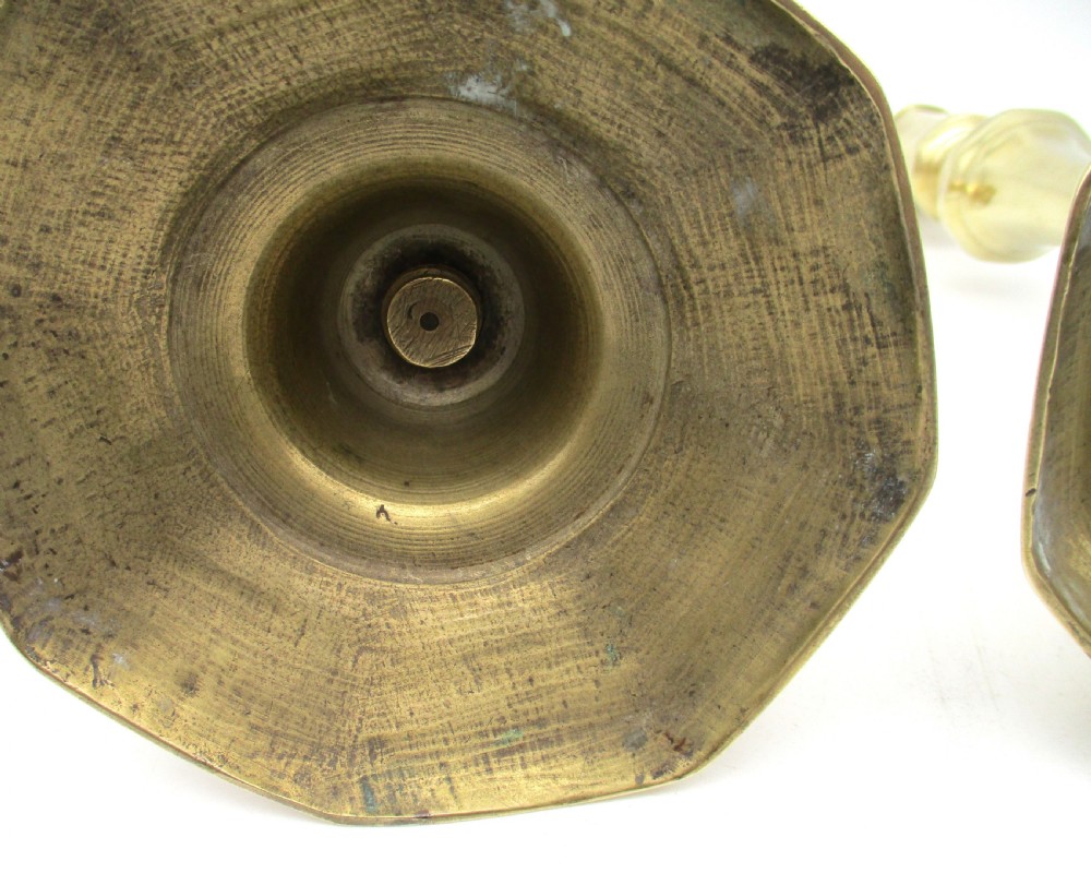 A matching pair of yellow-gold brass candlesticks featuring octagonal stepped bases and knopped stems. View VII