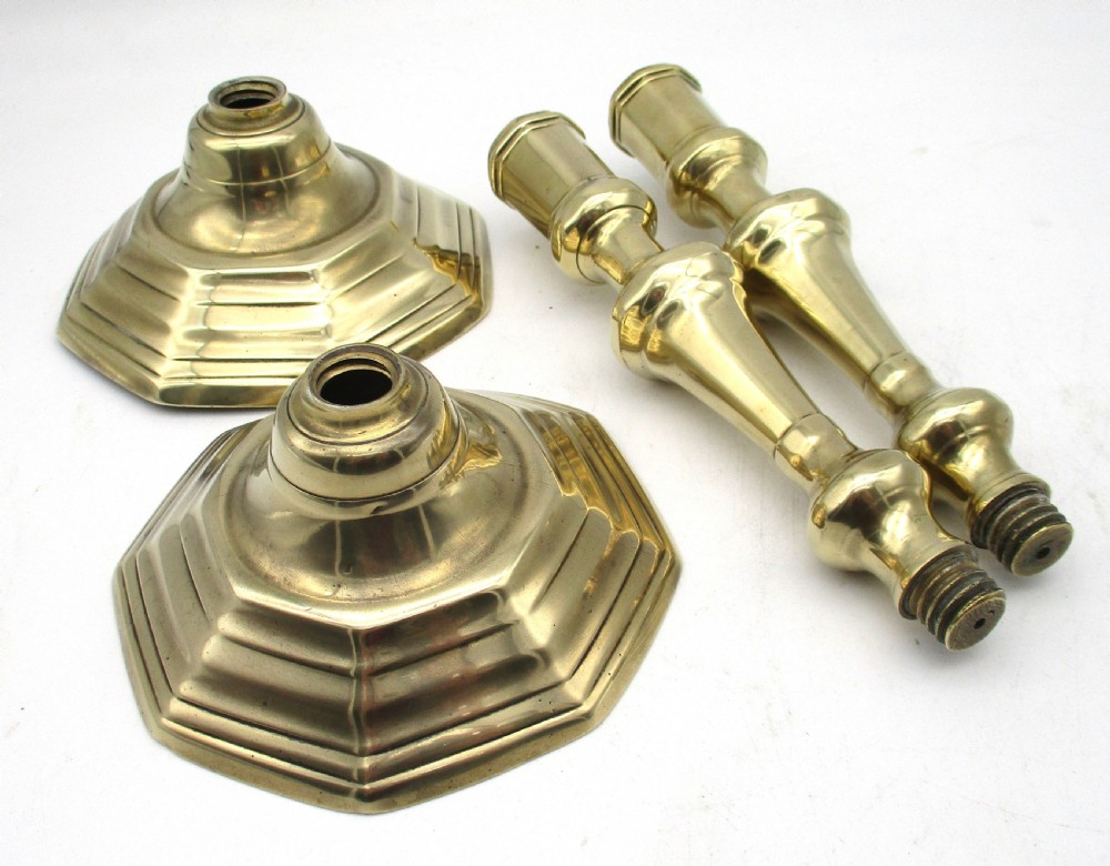 A matching pair of yellow-gold brass candlesticks featuring octagonal stepped bases and knopped stems. View VIII