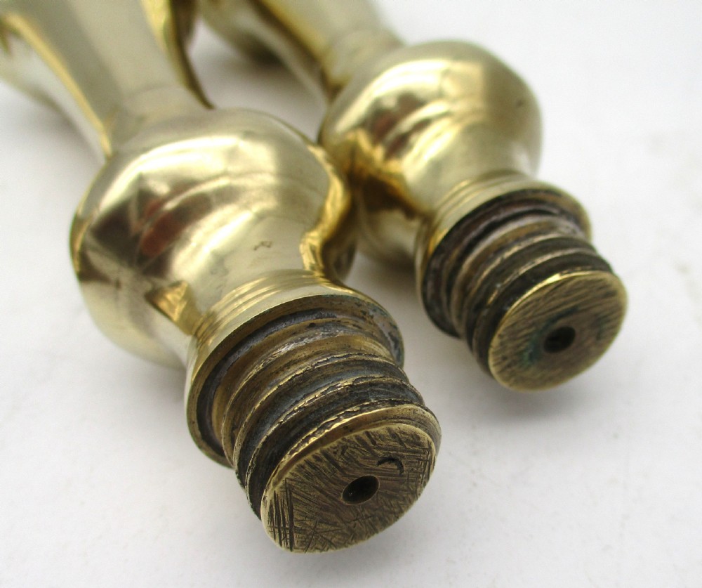 A matching pair of yellow-gold brass candlesticks featuring octagonal stepped bases and knopped stems. View IX