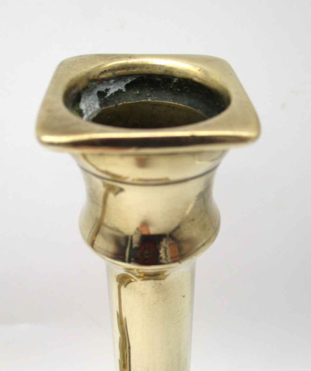A pair of antique brass column candlesticks featuring fluted shafts and stepped square bases. View VI