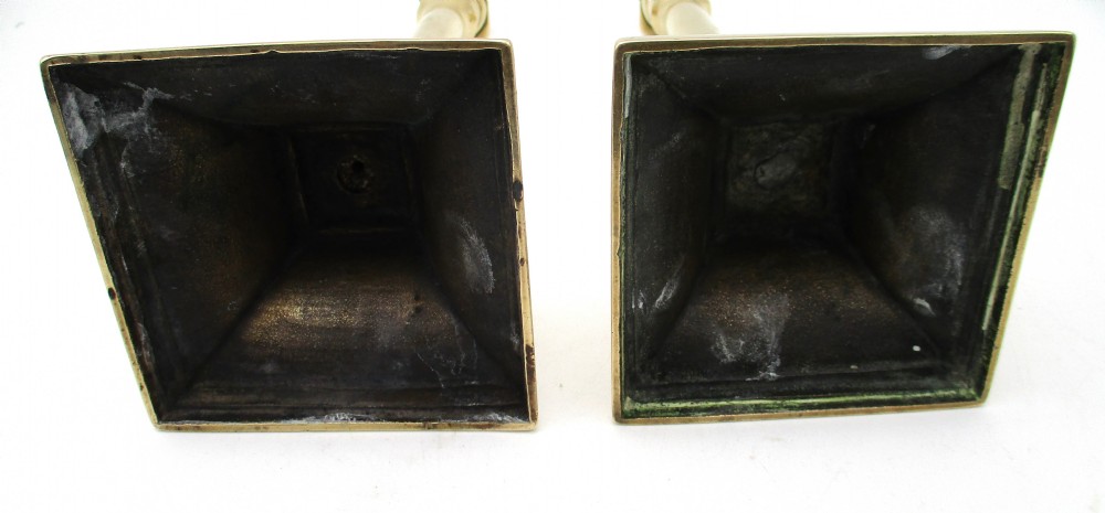 A pair of antique brass column candlesticks featuring fluted shafts and stepped square bases. View IX