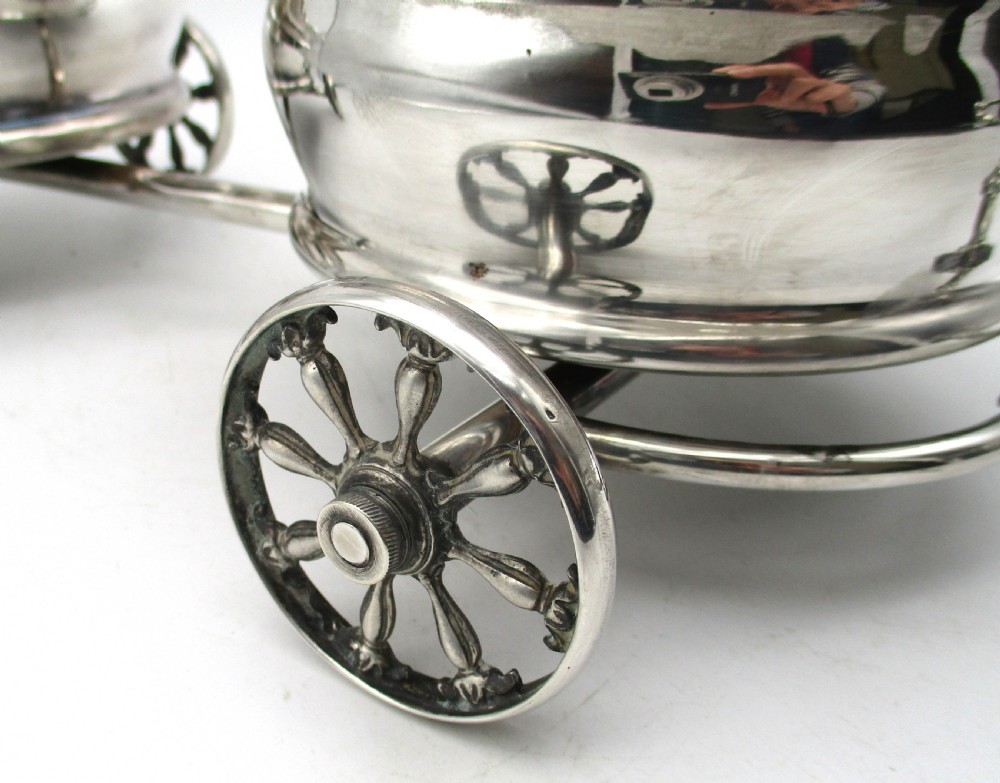 A pair of 19th-century silver-plated decanter coasters mounted on a wheeled carriage trolley with turned wooden bases and a decorative handle. View III