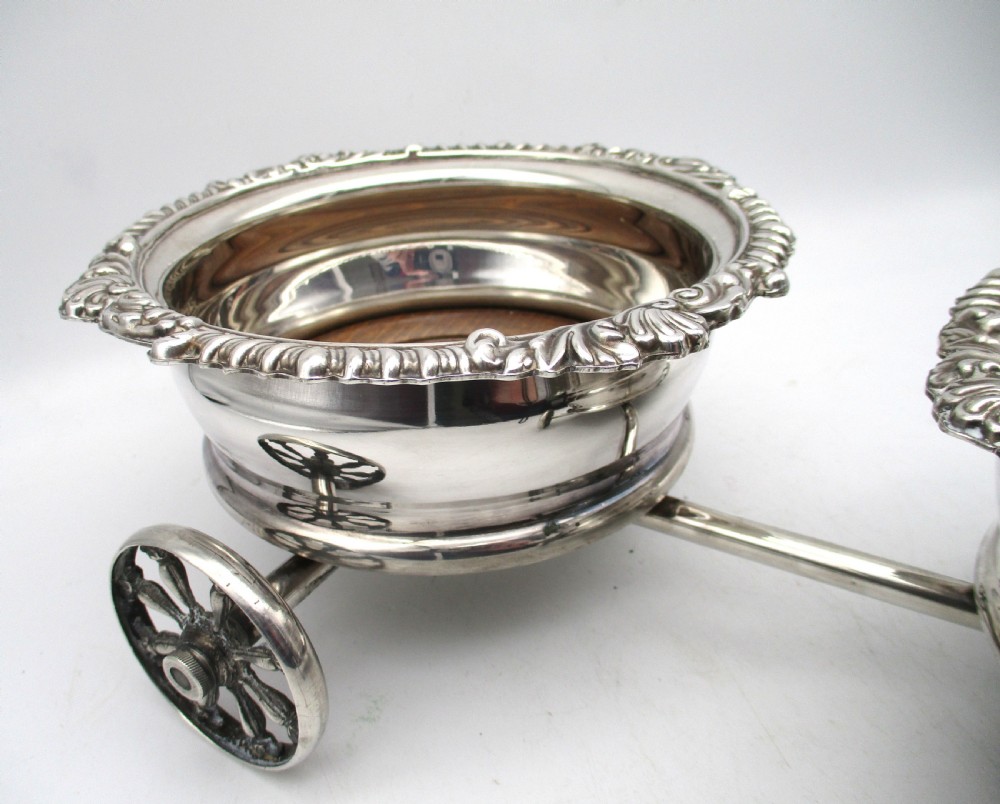 A pair of 19th-century silver-plated decanter coasters mounted on a wheeled carriage trolley with turned wooden bases and a decorative handle. View IV