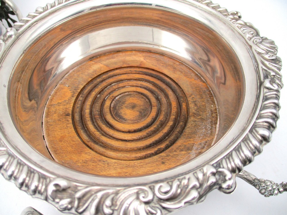 A pair of 19th-century silver-plated decanter coasters mounted on a wheeled carriage trolley with turned wooden bases and a decorative handle. View IX