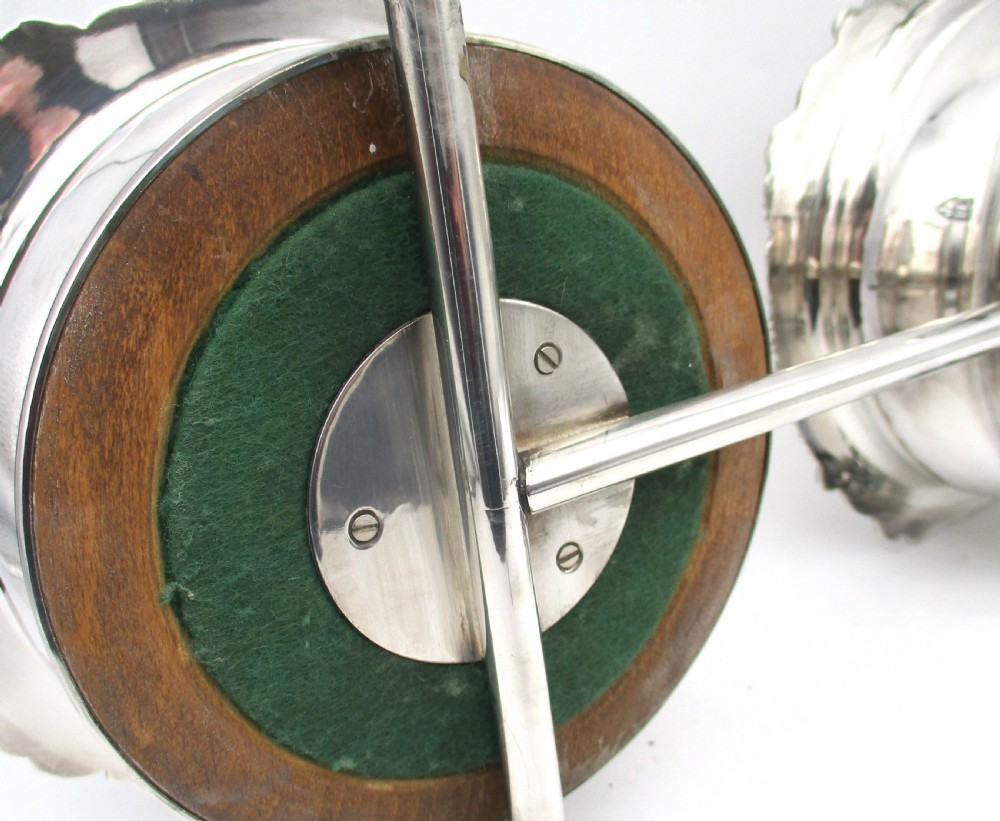 A pair of 19th-century silver-plated decanter coasters mounted on a wheeled carriage trolley with turned wooden bases and a decorative handle. View XI