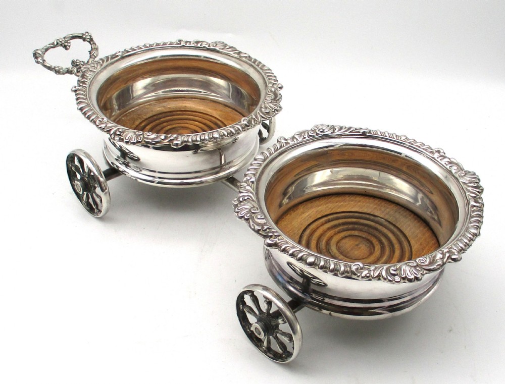 A pair of 19th-century silver-plated decanter coasters mounted on a wheeled carriage trolley with turned wooden bases and a decorative handle. View XII