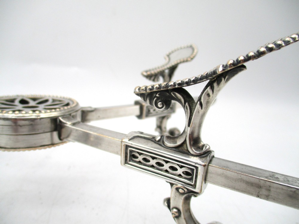 An antique Georgian Sheffield plated silver dish cross featuring four adjustable sliding arms with beaded support pads and feet. View VIII