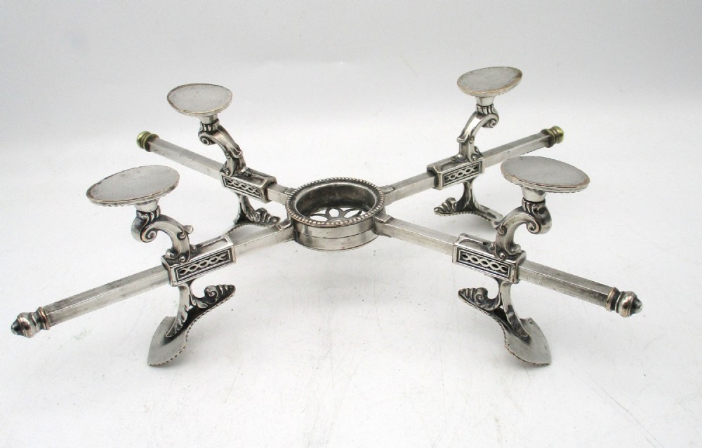 An antique Georgian Sheffield plated silver dish cross featuring four adjustable sliding arms with beaded support pads and feet. View X