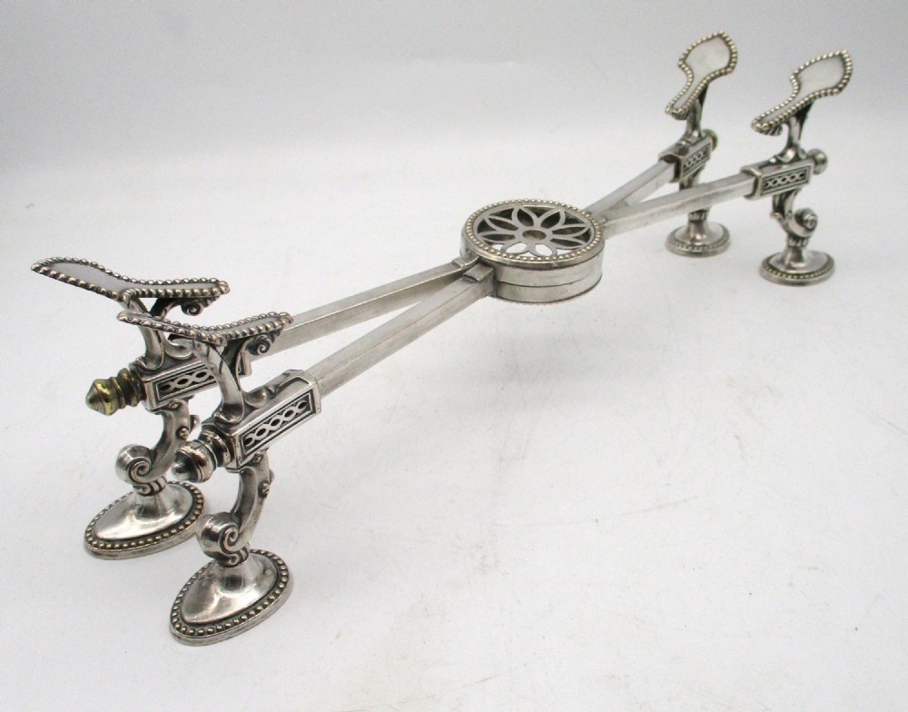 An antique Georgian Sheffield plated silver dish cross featuring four adjustable sliding arms with beaded support pads and feet. View XIII