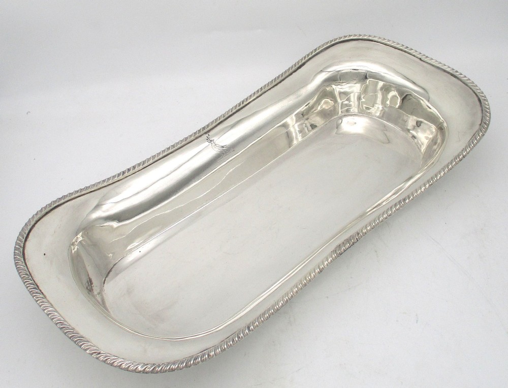An elongated 19th-century silver-plated knife tray with a gadrooned rope-twist border rim and an engraved motif on the inner wall.