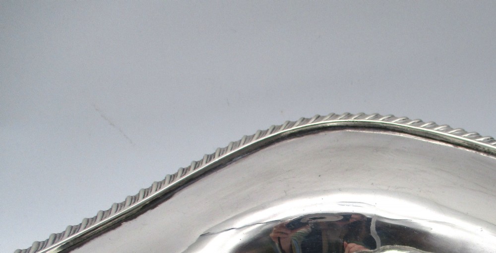 An elongated 19th-century silver-plated knife tray with a gadrooned rope-twist border rim and an engraved motif on the inner wall. View VI