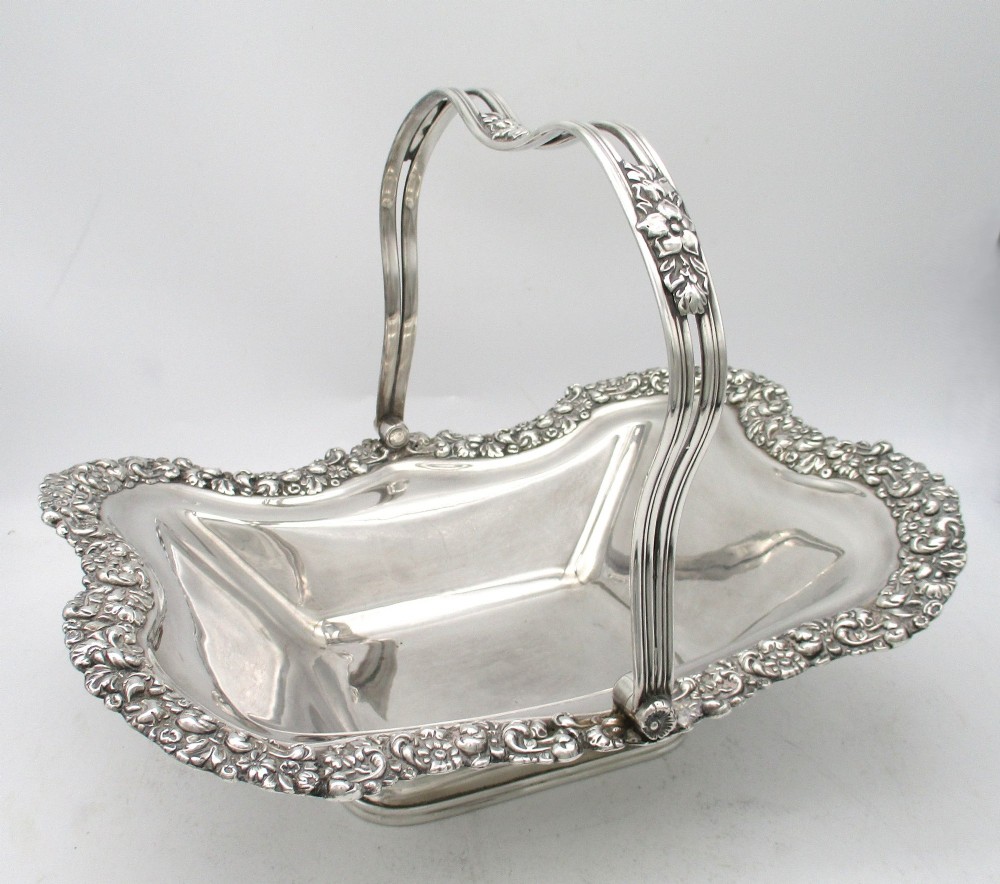 A Regency silver-plated fruit basket featuring a lobed rim with embossed floral motifs and a hinged overhead handle. View II