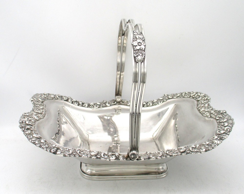 A Regency silver-plated fruit basket featuring a lobed rim with embossed floral motifs and a hinged overhead handle. View IV