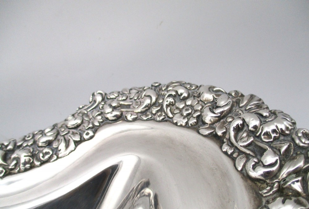 A Regency silver-plated fruit basket featuring a lobed rim with embossed floral motifs and a hinged overhead handle. View V