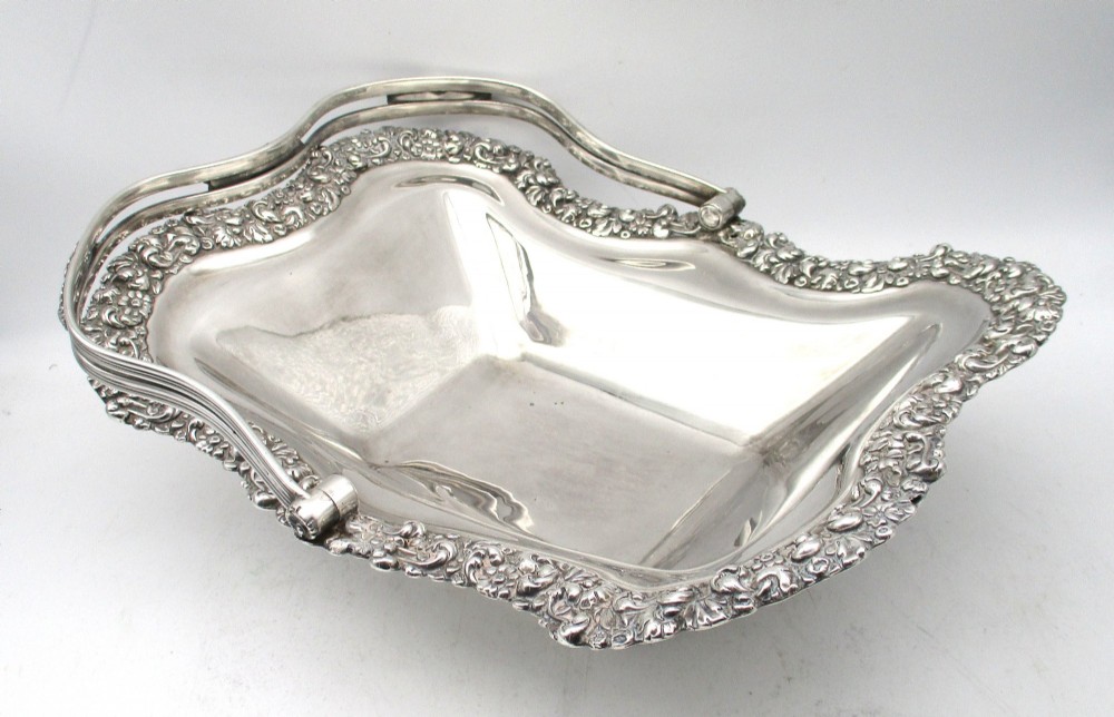 A Regency silver-plated fruit basket featuring a lobed rim with embossed floral motifs and a hinged overhead handle. View VI