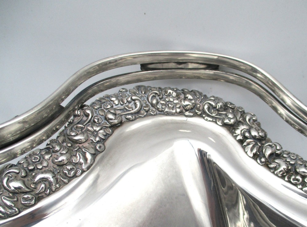 A Regency silver-plated fruit basket featuring a lobed rim with embossed floral motifs and a hinged overhead handle. View VII
