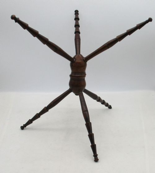 A Georgian turned dark mahogany fire cat featuring six radiating spoked arms attached to a central turned baluster hub. View II