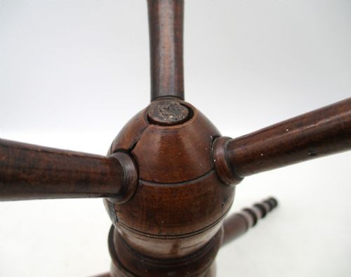 A Georgian turned dark mahogany fire cat featuring six radiating spoked arms attached to a central turned baluster hub. View IV