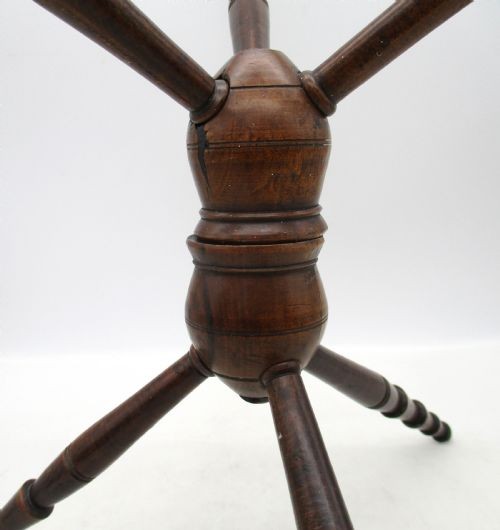A Georgian turned dark mahogany fire cat featuring six radiating spoked arms attached to a central turned baluster hub. View V