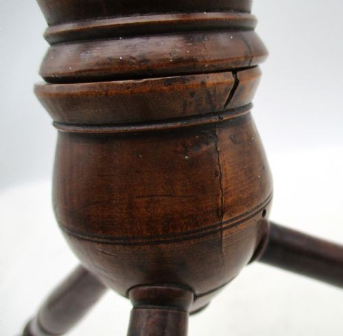 A Georgian turned dark mahogany fire cat featuring six radiating spoked arms attached to a central turned baluster hub. View VII