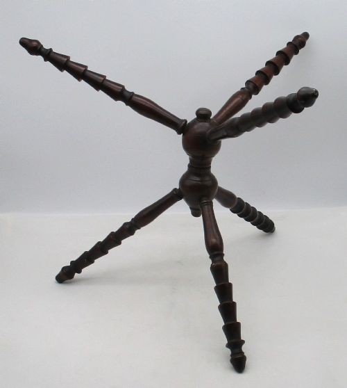 An antique Georgian dark mahogany wooden fire cat featuring six turned spindle limbs connected to a central turned joint. View II