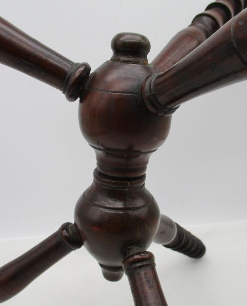 An antique Georgian dark mahogany wooden fire cat featuring six turned spindle limbs connected to a central turned joint. View IV
