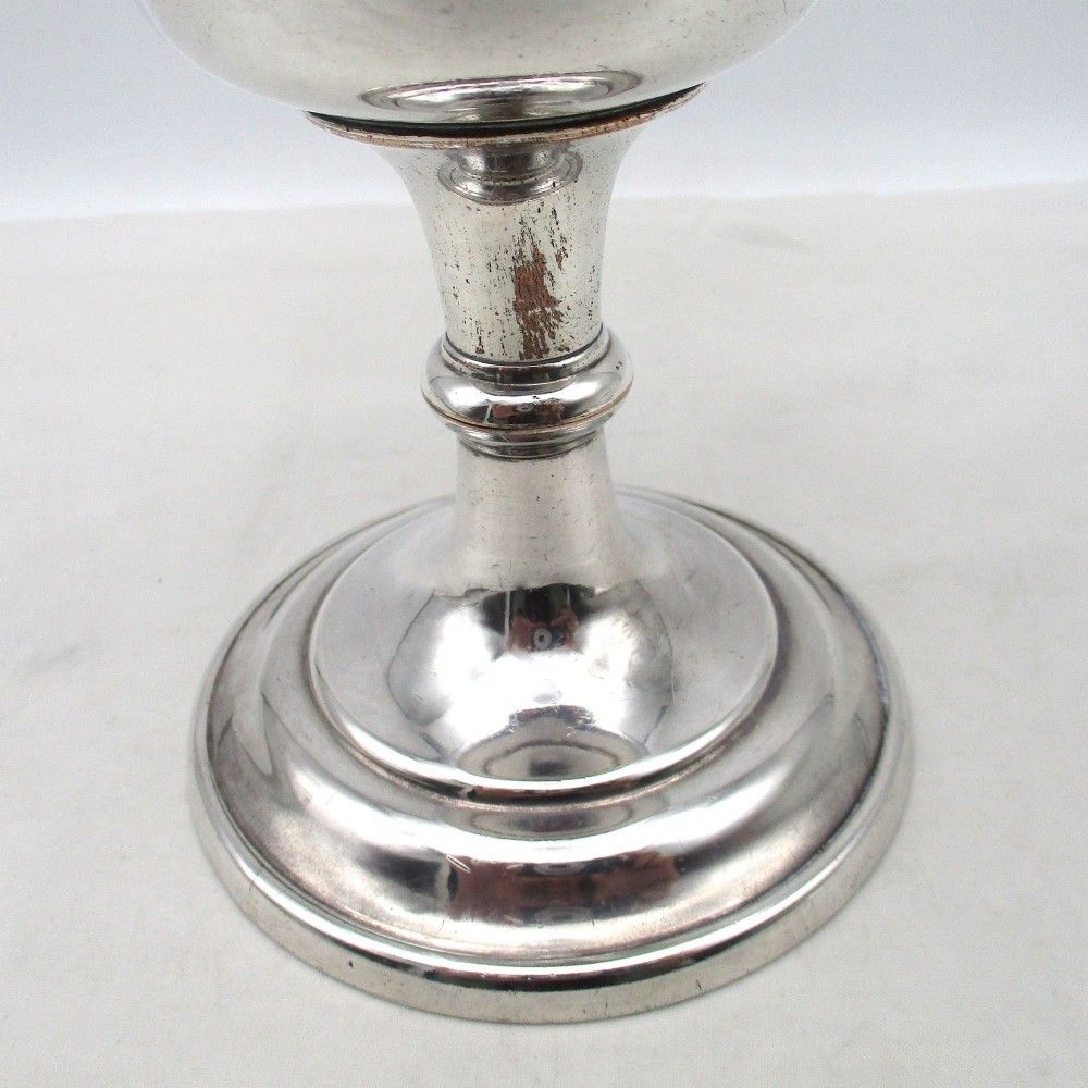 A 19th-century silver-plated church chalice featuring a flared cup with an engraved IHS Christogram medallion, a knopped stem, and a stepped circular base. View IV