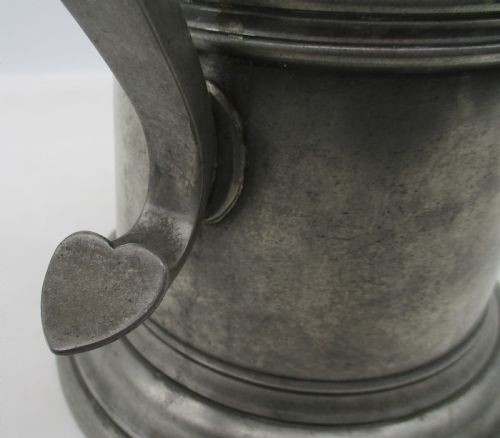 A pair of matching 19th-century pewter communion flagons featuring domed hinged lids, thumbpiece levers, scroll handles, and engraved inscriptions on the cylindrical bodies. View IX