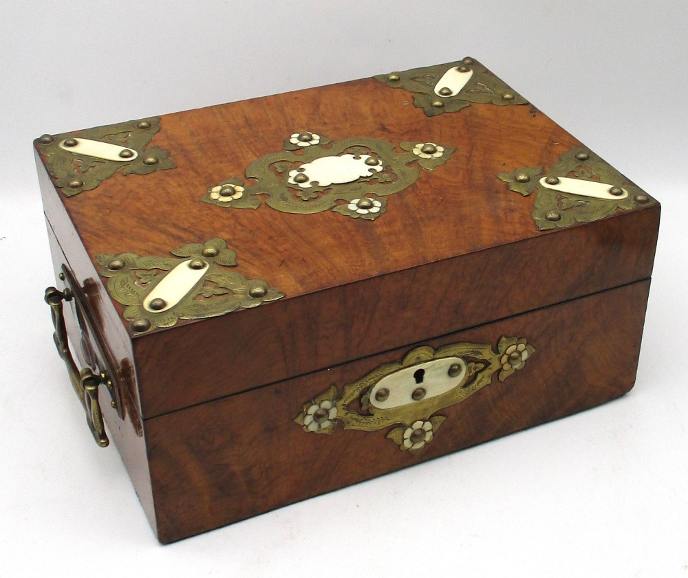 A rectangular warm brown wooden jewellery box decorated with polished brass corner mounts, bone inlays, and side carrying handles.