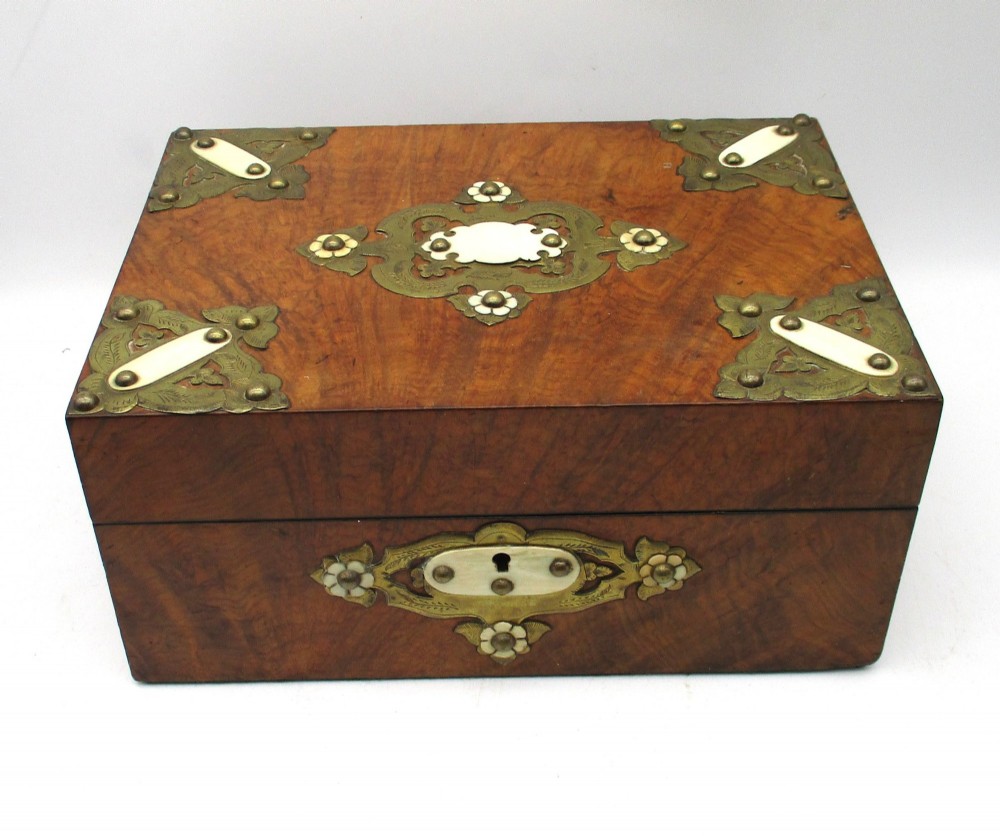A rectangular warm brown wooden jewellery box decorated with polished brass corner mounts, bone inlays, and side carrying handles. View II